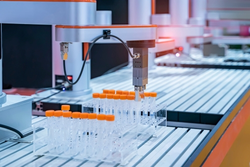automation lines with robot arms filling and moving test tubes with caps
